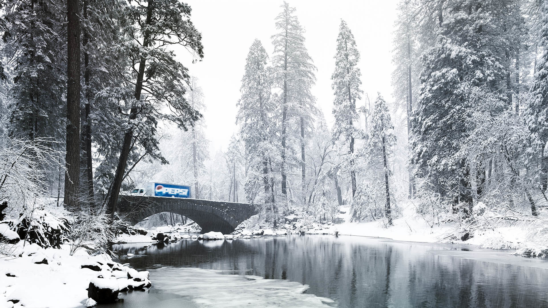 Stone bridge over frozen river in white snowy forest